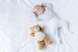 why do babies sleep with their arms up